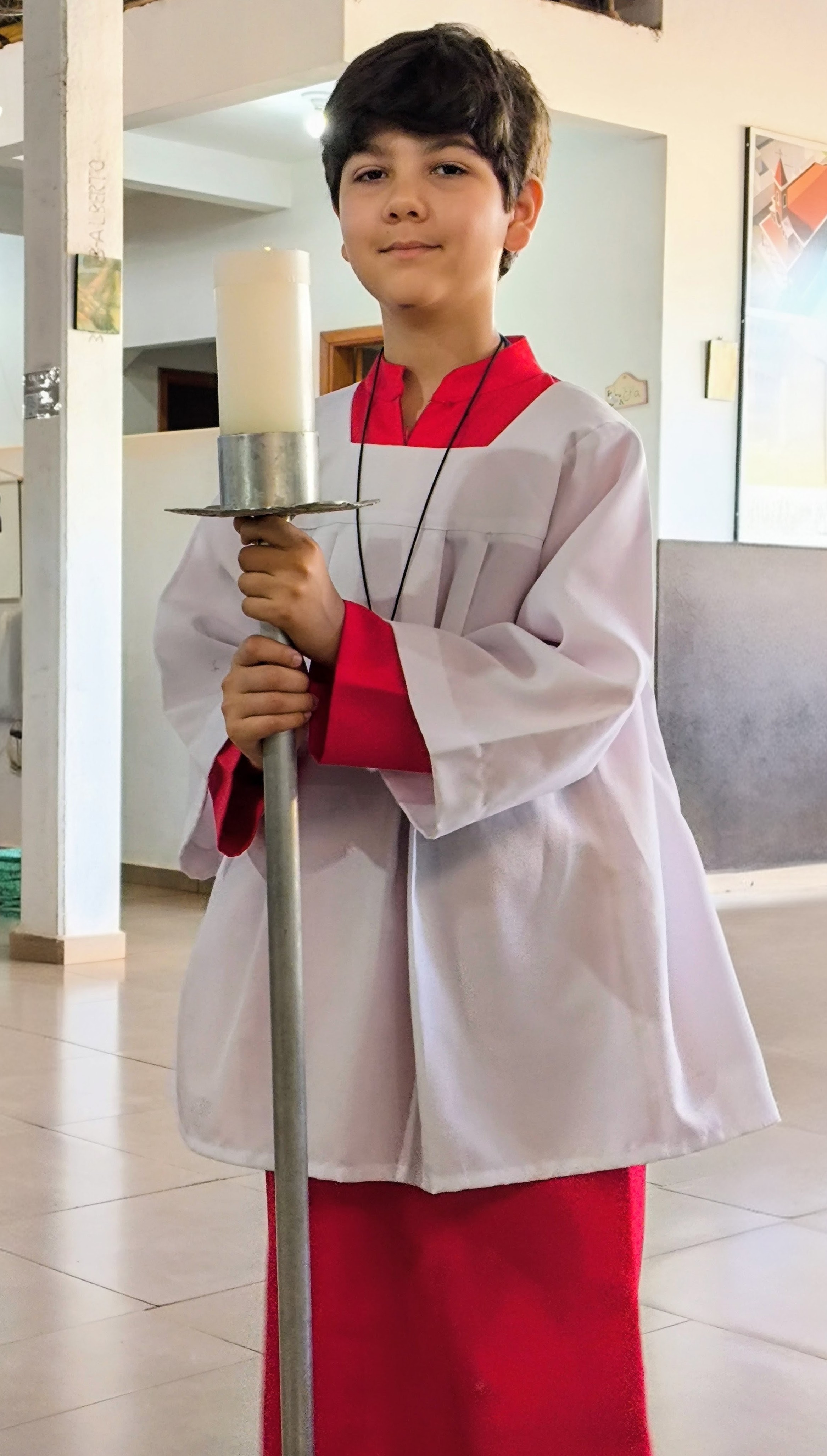 Filho mais velho como coroinha segurando a vela